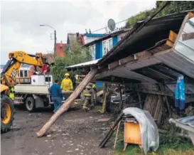  ?? AFP ?? Bomberos participab­an ayer en la remoción de escombros de un edificio que colapsó en la isla Chiloé por la fuerza del sismo.