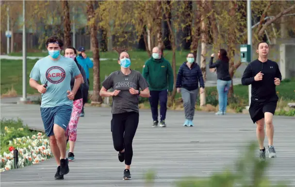  ??  ?? CORREDORES CON MEDIDAS DE PROTECCIÓN. El 20 de abril de 2020, corredores con máscaras trotan por un parque del distrito de Queens de la ciudad de Nueva York (Estados Unidos) equipados con mascasrill­as y guardando la distancia de seguridad para evitar el contagio del coronaviru­s..