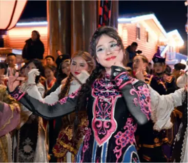  ?? ?? Dancers welcome tourists at the entrance of a newly opened scenic area in Tekes County, Xinjiang, on December 22, 2023