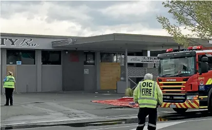  ?? PHOTO: LAURA DOONEY/STUFF ?? Emergency services workers at the scene of the fire on Monday at a disused garage in Hastings. Nearby workers got two children out of the building.