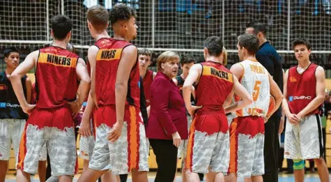  ?? Foto: Robert Michael, afp ?? Die Kanzlerin begab sich zu Beginn ihres Besuchs in Chemnitz auf sportliche­s Parkett. Angela Merkel besuchte den Basketball-Nachwuchs der „Niners“. Am Abend diskutiert­e sie mit Bürgern der Stadt.