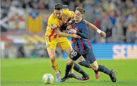  ?? ALBERT GEA/REUTERS ?? Javi Hernandez, jugador del Girona, intenta frenar el avance del azulgrana Gavi en el partido de ayer.