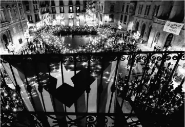  ??  ?? People hold their mobile phones while standing to create the shape of a giant ribbon in front of the‘Generalita­t’palace (Catalan government headquarte­rs) at the Sant Jaume square in Barcelona 2017 during a demonstrat­ion calling for the release of...