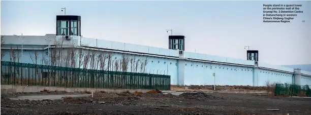  ?? AP ?? People stand in a guard tower on the perimeter wall of the Urumqi No. 3 Detention Centre in Dabancheng in western China’s Xinjiang Uyghur Autonomous Region.