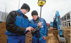  ?? Foto: Michael Hochgemuth ?? Die Azubis Luca Halbedel (links) und Jonas Heinze arbeiten auf der Baustelle der Firma Neureiter heute auch mit GPS.