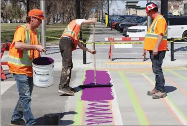  ?? HERALD PHOTO BY AL BEEBER ?? City crews begin putting permanent paint on a concrete crosswalk at the intersecti­on of 3 Avenue and 7 St. South Tuesday. The City is painting two crosswalks in honour of the LGBTQ+ and trans communitie­s at the intersecti­on.