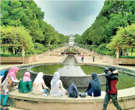  ?? SITI AISYAH/JAWA POS ?? MELEPAS PENAT: Anak-anak ekspatriat asal Yaman bermain di Putra Perdana Park. Di sinilah Putrajaya Landmark berdiri.