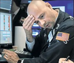  ??  ?? Rough day: A trading specialist on the floor of the New York Stock Exchange looked glum Wednesday, after the Dow shed 800 points.