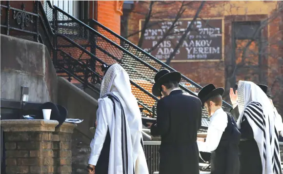  ?? (Andrew Kelly/Reuters) ?? MORNING PRAYERS outside of a synagogue, closed due to coronaviru­s, in South Williamsbu­rg, Brooklyn.