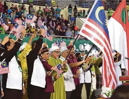  ?? BERNAMA PIC ?? Pas president Datuk Seri Abdul Hadi Awang (centre, in green) and the party’s leadership waving the Jalur Gemilang in conjunctio­n with Malaysia Day at the 64th Pas Muktamar in Gong Badak, Kuala Nerus, yesterday.