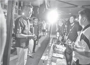  ??  ?? CALVIN (kiri) beramah-mesra dengan para peniaga ketika tinjauan turun padang ke Pasar Malam Kim Fung.