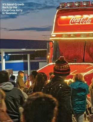  ??  ?? It’s here! Crowds flock to the Coca-Cola lorry in Swansea