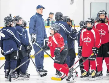  ?? CP PHOTO ?? Pittsburgh Penguins captain Sidney Crosby helps organize a drill during an on-ice session at the Sidney Crosby Hockey School in Halifax on Wednesday.