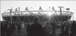  ?? By Alastair Grant, AP ?? Going for the gold: Workers are putting finishing touches on Olympic Park in East London. The site will feature an 80,000-seat stadium, shown here, and aquatic center.