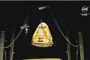  ?? SOURCE: NASA ?? This image from video supplied by NASA shows the SpaceX Dragon capsule being lifted out of the water after splashing down in the Gulf of Mexico early Friday.