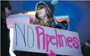  ?? — THE CANADIAN PRESS FILES ?? Julie Dujardin holds a sign during a protest against the Kinder Morgan Trans Mountain pipeline expansion.