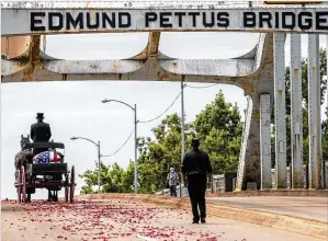  ?? ALYSSA POINTER / ALYSSA.POINTER@AJC.COM ?? The body of Rep. John Lewis is taken Sunday by horse-drawn caisson across the Edmund Pettus Bridge in Selma, Alabama, in a ceremonial farewell crossing.