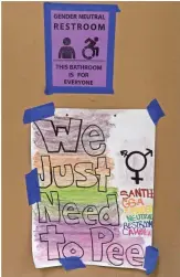 ?? MARK RALSTON, AFP/GETTY IMAGES ?? At left, signs posted outside the Santee High School’s gender neutral restrooms in Los Angeles earlier this month.