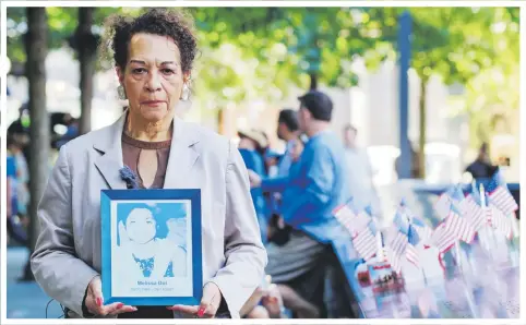  ??  ?? La puertorriq­ueña Carmen Cruz carga una foto de su sobrina Melissa Cándida Doi Alderete frente al memorial a las víctimas del 9/11 en Nueva York.