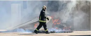  ?? LEON LESTRADE African News Agency (ANA) ?? CITY firefighte­rs yesterday tested fire retardant paint that is being considered to reduce the impact of informal settlement fires. The burn simulation comprised six structures in total - five made from corrugated iron and one from wood.
|