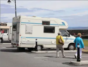  ??  ?? Camper vans parked along the seafront in Mullaghmor­e last Thursday morning. Locals say it remains an issue despite new bollards having been erected to prevent illegal parking-up.