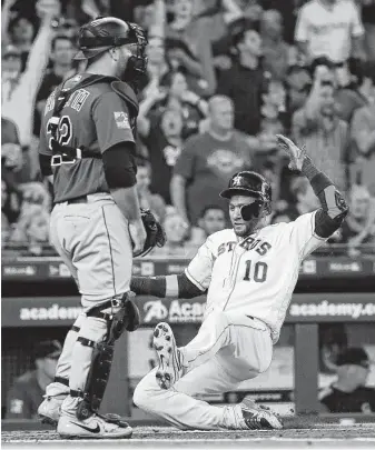  ?? Karen Warren / Staff photograph­er ?? Yuli Gurriel comes home on Carlos Correa’s double in the first inning as the Astros scored early and often during a 12-1 victory over the Rockies on Wednesday night.