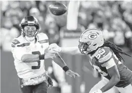  ?? DEAN RUTZ/THE SEATTLE TIMES ?? Pursued by Packers linebacker De’Vondre Campbell, right, Seahawks quarterbac­k Russell Wilson tries to get off a pass that missed its target on Sunday at Lambeau Field in Green Bay, Wisconsin.