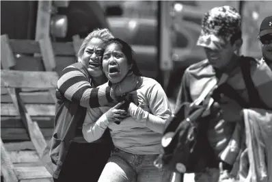  ?? Tribune News Service ?? ■ Concepcion Ventura, left, shown June 1, 2018, with daughter Aidali Jeronimo, 21, and husband Daniel Lopez, on scene where her son Jonathan Ventura Citalan, 18, was shot and killed in broad daylight in front of their house along Calle Privada Vizcaino in Fraccionam­iento Villa Del Alamo, Tijuana, Mexico. Jonathan was involved in low-level drug dealing. The manufactur­ing of crystal meth in Mexico, with a dose costing as little as $2, has fueled the rise in consumptio­n.