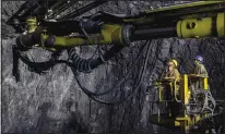  ?? ?? Kashmiri worker Tariq Ahmed Lone (right) stands Tuesday on a crane along with another worker employed by Megha Engineerin­g And Infrastruc­tures Limited as they work inside the Nilgrar Tunnel.