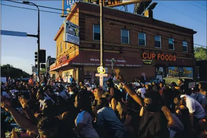  ?? BEBETO MATTHEWS — THE ASSOCIATED PRESS ?? People gather near the Cup Foods grocery store on June 1 in Minneapoli­s, where George Floyd died. Floyd was accused of using a fake $20 bill to buy cigarettes from the grocery store. His story is similar to that of other African Americans who died at the hands of police over minor offenses.