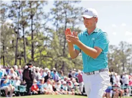  ??  ?? Jordan Spieth applauds on the 18th green following his first round of the Masters Thursday in Augusta, Ga. He is currently in first place with a 6-under 66.