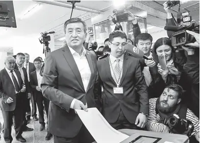  ?? — Gambar Reuters ?? UTAMA: Jeenbekov membuang undi di sebuah pusat pengundian semasa pilihan raya presiden di Bishkek, semalam.