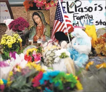  ?? Mario Tama Getty Images ?? FLOWERS AND other mementos fill a makeshift memorial near the Walmart in El Paso where a gunman killed 20 people, including U.S. and Mexican citizens. Some loved ones paid tribute to the victims online.