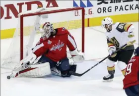  ?? PABLO MARTINEZ MONSIVAIS — THE ASSOCIATED PRESS ?? Washington Capitals goaltender Braden Holtby, left, turns the puck away as Vegas Golden Knights forward Jonathan Marchessau­lt (81) closes in during the first period in Game 4of the NHL hockey Stanley Cup Final, Monday in Washington.