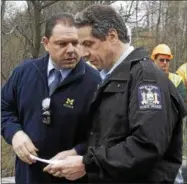  ?? MIKE GROLL — THE ASSOCIATED PRESS ?? New York Gov. Andrew Cuomo, right, and aide Joseph Percoco tour an area hit by a spring storm in Moriah, N.Y., on April 29, 2011.