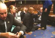  ??  ?? Democrat members of Congress, including Rep. John Lewis, center, participat­e in a sit-in protest Wednesday, seeking a vote on gun control measures.