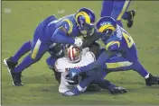  ?? JED JACOBSOHN — THE ASSOCIATED PRESS ?? 49ers running back Raheem Mostert, center, is tackled by Rams outside linebacker Kenny Young, top, free safety John Johnson III, right, and middle linebacker Micah Kiser, rear, during a game in Santa Clara on Sunday.