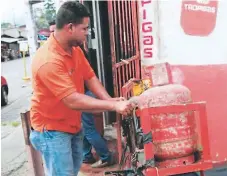  ??  ?? CONSUMO. Un trabajador carga un chimbo de gas.