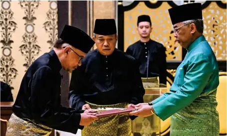  ?? FINALLY
AP ?? Malaysia’s King Sultan Abdullah and newly appointed PM Anwar Ibrahim take part in the swearing-in ceremony in Kuala Lumpur, Malaysia, on Thursday.