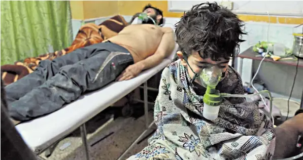  ??  ?? A Syrian child and an adult receive treatment at a makeshift clinic after a suspected chemical attack on the rebel-held village of al-shifuniyah in the Eastern Ghouta region on the outskirts of Damascus