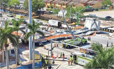  ?? ALAN GOMEZ/USA TODAY ?? Emergency workers respond to a collapsed pedestrian bridge at Florida Internatio­nal University on Thursday in the Miami area. Search-and-rescue teams used dogs and cranes to go through the rubble.