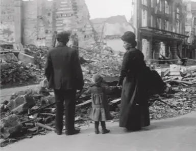  ??  ?? Above: A refugee family returning to Amiens in northern France, looking at the ruins of a house