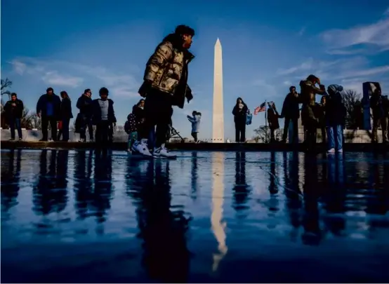  ?? OLIVER CONTRERAS/AFP VIA GETTY IMAGES ?? COLD REFLECTION — People played on the frozen Reflecting Pool on the National Mall near the Washington Monument on Wednesday in Washington.