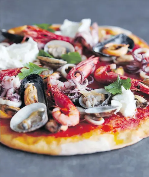  ?? LISA LINDER ?? Mussels, clams, prawns, crabmeat and baby squid adorn this seafood pizza. Once the dough is ready and the oven is hot, you can make your pie in well under an hour.