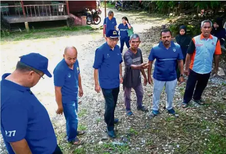  ??  ?? Going to the ground: Dr Mah (centre) chatting with locals during a walkabout in Bidor, Perak.