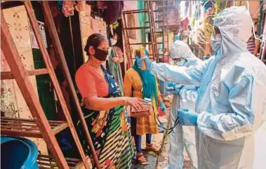  ??  ?? Medical workers conducting door-to-door medical screening in the Dharavi slums of Mumbai, India, recently.