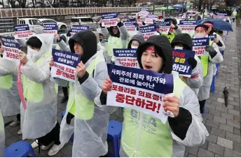  ?? — AFP photo ?? Doctors hold placards reading ‘Stop populist medical policy!’ during a rally to protest against the government’s plan to raise the annual enrolment quota at medical schools, near the presidenti­al office in Seoul.