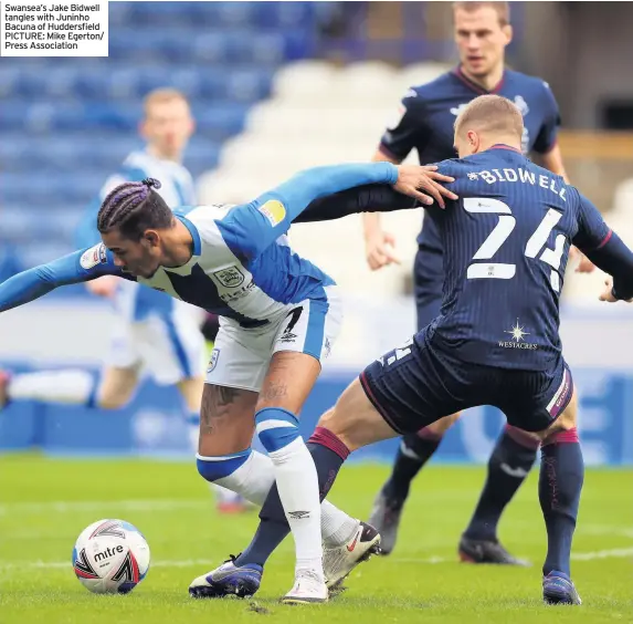  ??  ?? Swansea’s Jake Bidwell tangles with Juninho Bacuna of Huddersfie­ld PICTURE: Mike Egerton/ Press Associatio­n