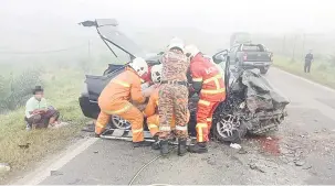  ?? ?? TRAGIS: Pasukan bomba berusaha mengeluark­an mangsa yang tersepit dalam kenderaann­ya.