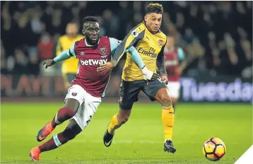  ??  ?? Arsenal’s Alex Oxlade-Chamberlai­n fends off Angelo Ogbonna.